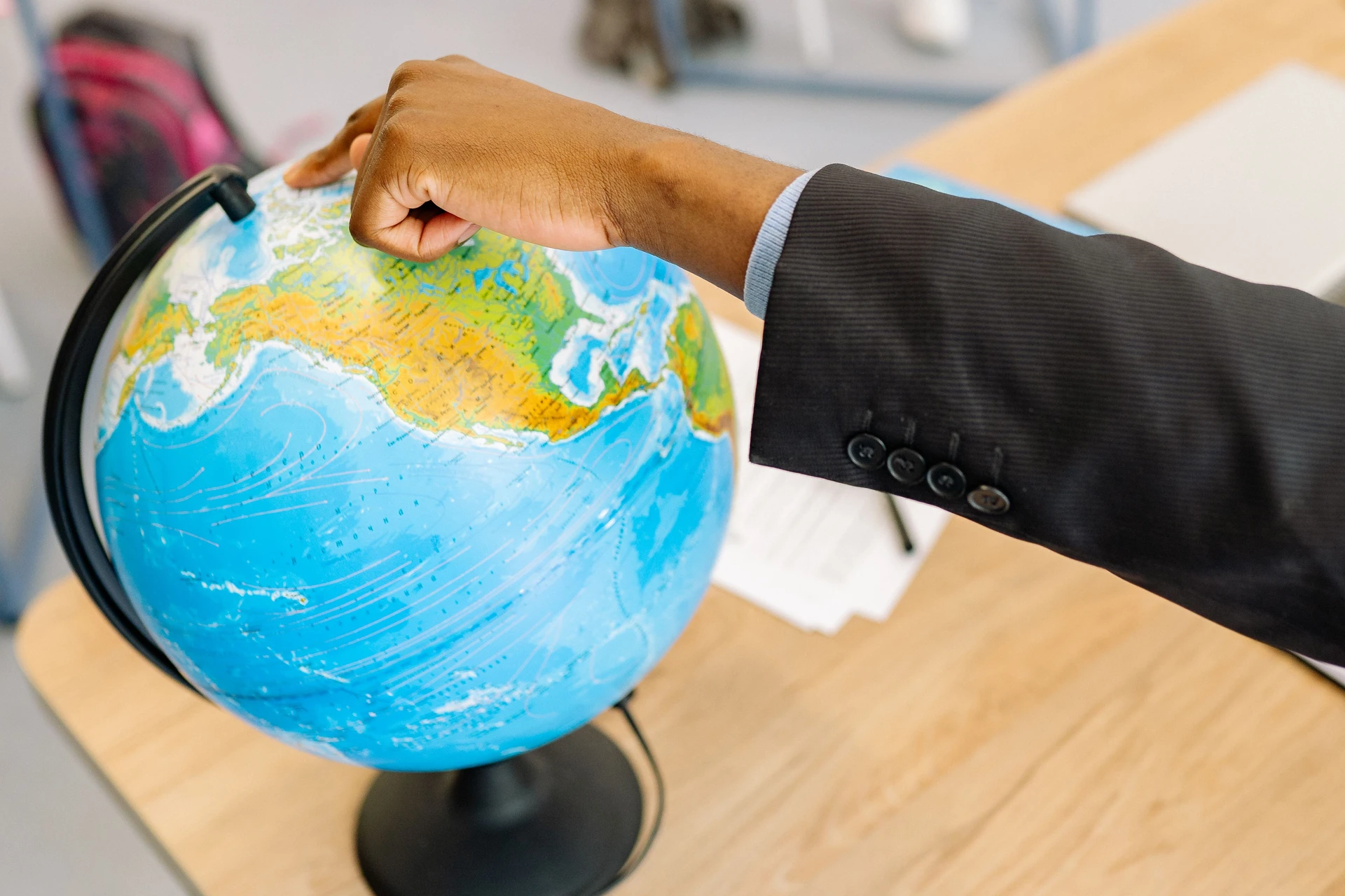 Person placing finger on a location on the globe