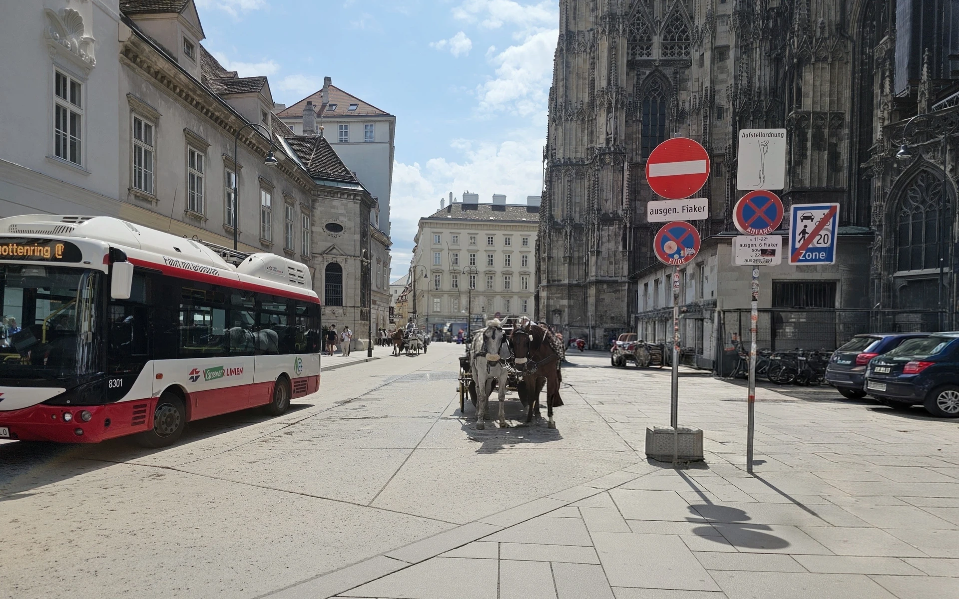 Stephansplatz in Vienna, photographed by the author in 2025: St. Stephen's Cathedral, a Wiener Linien bus and a horse-drawn Fiaker carriage, with passers-by's faces masked or removed by AI for privacy