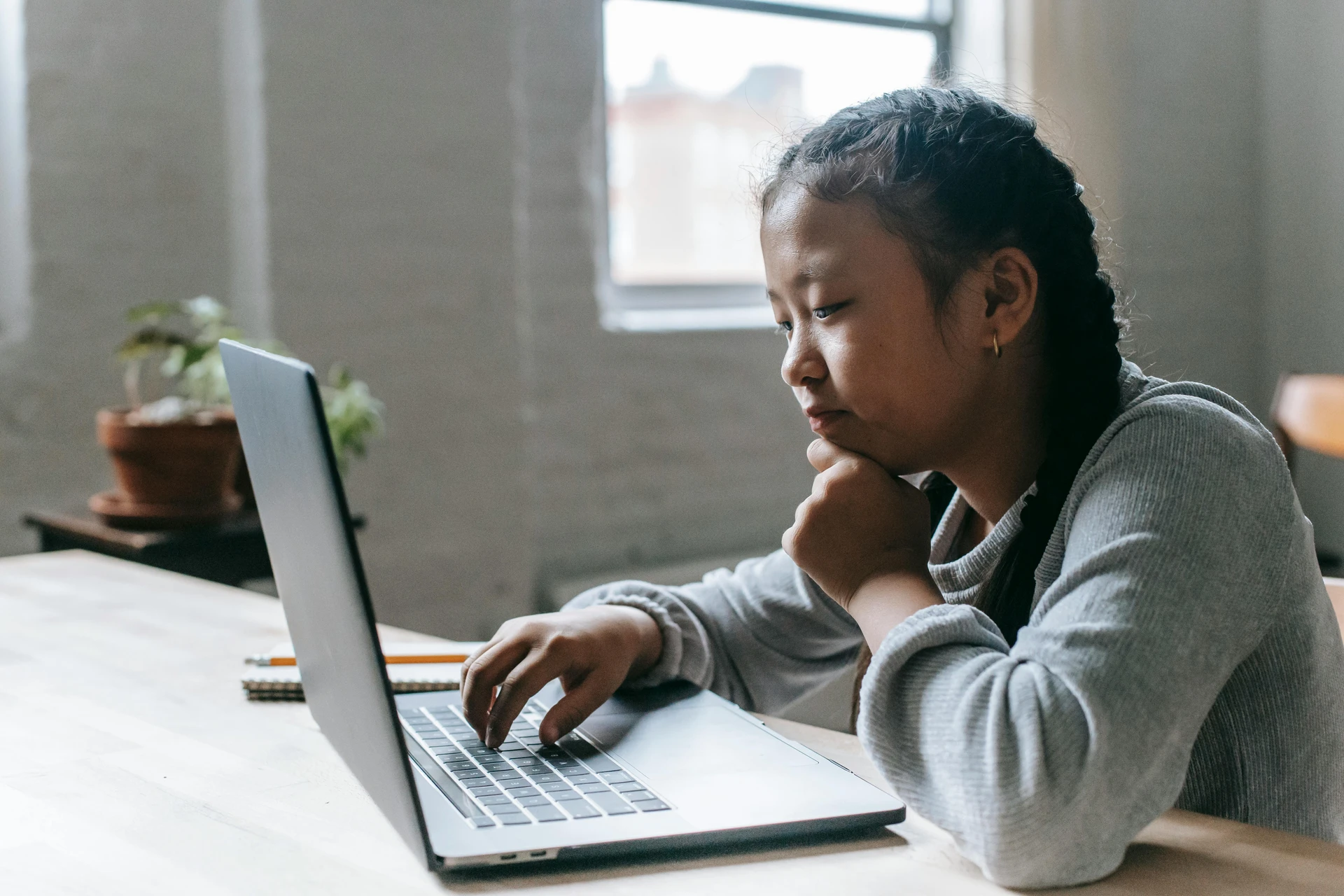Girl thinking while playing online quiz
